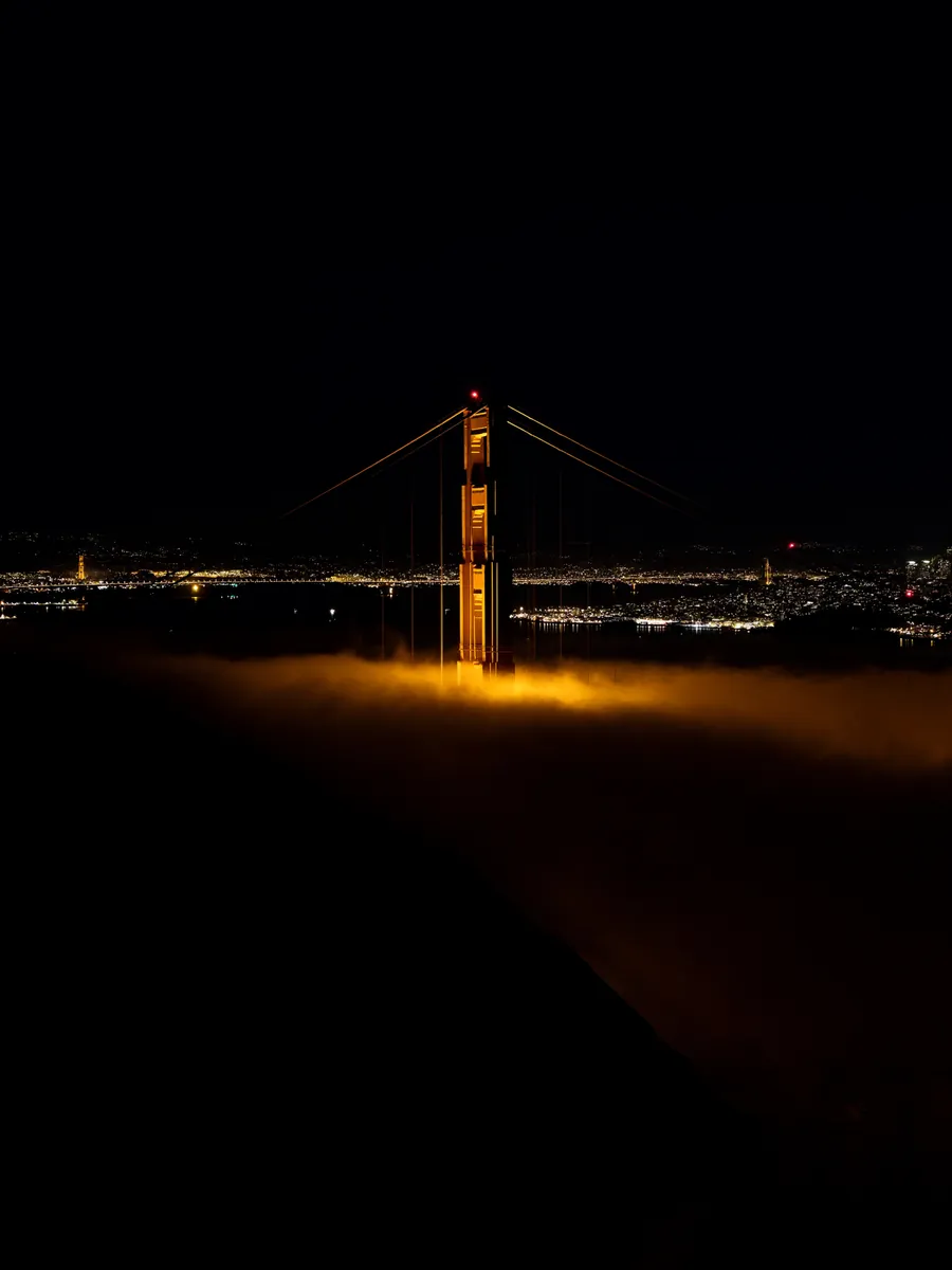 Puente Golden Gate iluminado sobre la niebla de noche, San Francisco